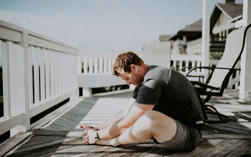 man stretching on a deck